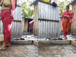 Hidden camera footage of a Bangladeshi village homemaker taking a bath outdoors.